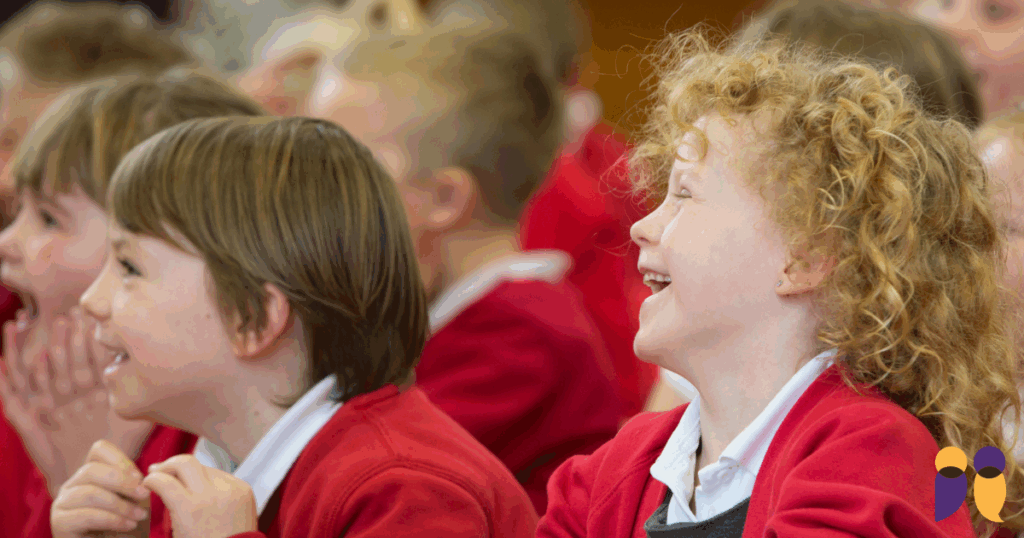 Storytelling in primary schools - two children in school uniform watch and laugh.